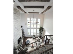 Wooden beams were added to the ceiling of this two-storey family room to give it a rustic feel.