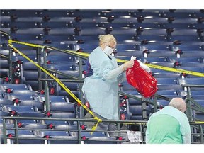 Workers clean a section of the lower seating area at Atlanta's Turner Field where a fan died after falling from the upper deck during a game between the Braves and the Yankees Saturday.