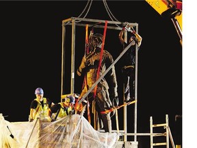 Workers prepare to dismantle one of the last Soviet-era statues remaining in Lithuania's capital Vilnius on Monday. Statues depicting Red Army soldiers, workers, students and peasants were erected on the city's historic Green Bridge in 1952.