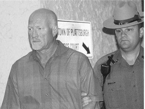 A New York State Police officer escorts suspended Clinton Correctional Facility guard Gene Palmer, left, from Plattsburgh Town Court in Plattsburgh, N.Y., on Wednesday.