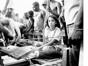 A young girl looks out from a wooden raft in 1994. Thousands of Cubans were building makeshift rafts and throwing them into the sea after then-president Fidel Castro said anyone who wanted to leave could flee.