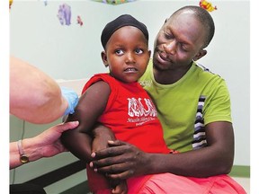 Zuhayra Nassuna and her father Abubaker Luwaga at the northeast health clinic for her immunizations on Thursday.