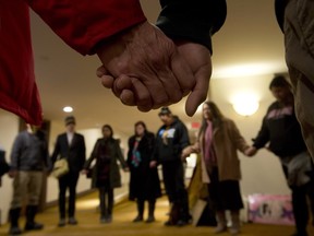 A group of aboriginal protesters hold hands during a prayer outside the National Roundtable on Missing and Murdered Indigenous Women and Girls on, Feb. 27, 2015, in Ottawa.