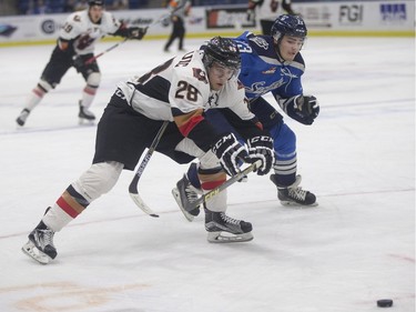 Saskatoon Blades' Schael Higson (R) pursues Calgary Hitmen's Tyler Mrkonjic in Saskatoon, November 25, 2015.