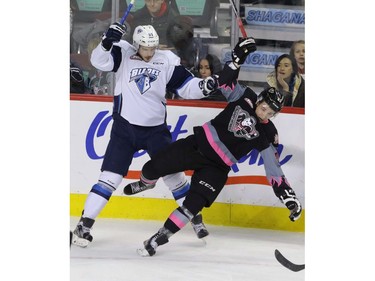 Calgary Hitmen's Taylor Sanheim is knocked over by Saskatoon Blades' Mitchell Wheaton in WHL action at the Scotiabank Saddledome in Calgary, November 22, 2015.