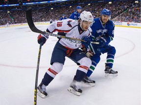Vancouver Canucks' Chris Tanev, right, checks Washington Capitals' Chandler Stephenson during the first period of an NHL hockey game in Vancouver, B.C., on Thursday October 22, 2015.