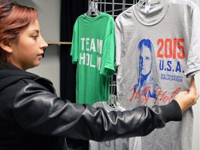 Deanna Bentacu, 22, stocks up on hot-selling T-shirts of new UFC women's bantamweight champion Holly Holm on Monday, Nov. 16, 2015, at the Jackson Wink MMA Academy in Albuquerque N.M. Albuquerque native Holm pulled off a stunning upset victory over Rousey in UFC 193, knocking out the women's bantamweight champion in the second round with a powerful kick to the head on Nov. 15, 2015.