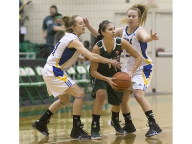 University of Saskatchewan Huskies guard Desarae Hogberg battles for the ball with University of British Columbia Thunderbirds Jessica Hanson (L) and Diana Lee in Women's CIS Basketball action, November 21, 2015.