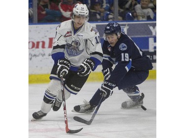 Saskatoon Blades defenceman Ryan Graham battles for the puck with  Victoria Royals forward Ryan Peckford during the first period of WHL action, November 1, 2015.