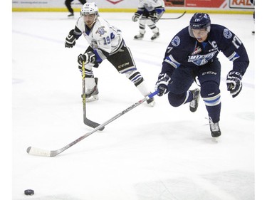 Saskatoon Blades forward Nick Zajac moves the puck away from Victoria Royals forward Dante Hannoun during the first period of WHL action, November 1, 2015.