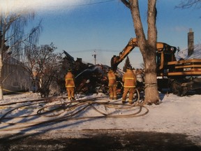Firefighters attend the scene of a house fire at 415 Avenue L North, owned by Jonathan Dombowsky's parents, on March 18, 2004.