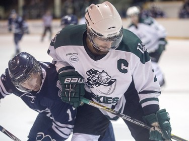 University of Saskatchewan Huskies captain Kendall McFaull and Mount Royal University Cougars' Tanner Olstad tangle during CIS men's hockey action at Rutherford Rink, November 27, 2015.