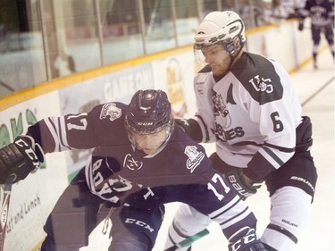 University of Saskatchewan Huskies' Jordan Franson and Mount Royal University Cougars' Tanner Olstad tangle in CIS men's hockey at Rutherford Rink in Saskatoon, November 27, 2015.