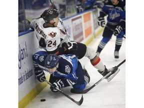 Saskatoon Blades Wyatt Sloboshan (underneath) and Calgary Hitmen's Carsen Twarynski collide on Nov.  3, 2015 in Saskatoon at SaskTel Centre.