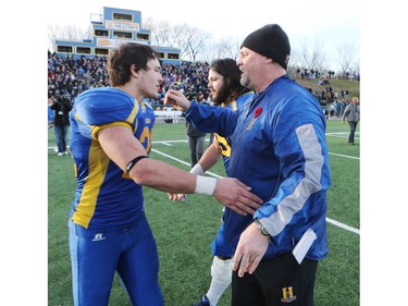 The Saskatoon Hilltops win their 18th national title 38-24 against the Okanagan Sun in Saskatoon, November 7, 2015. Players and coach Tom Sergeant embrace after the win.