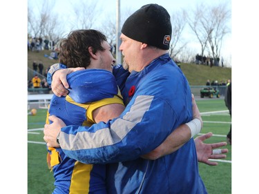 The Saskatoon Hilltops win their 18th national title 38-24 against the Okanagan Sun in Saskatoon, November 7, 2015. Players and coach Tom Sergeant embrace after the win.