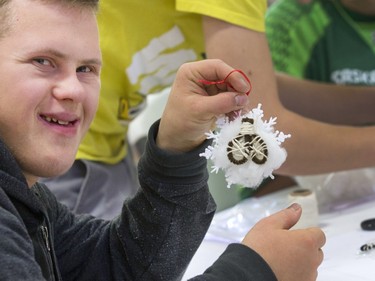 SASKATOON, SASK.; NOVEMBER  12, 2015 - 9999 features special   - (BestPhoto)  Houston Bergs is all smiles after creating his snowflake decoration with the theme sport of snowshoeing at decorating bee where Special Olympic Athletes spent the afternoon cutting, drawing and glueing hand made tree decorations with the different sports before placing them on the tree bound for the 2015 City Hospital Foundation's Festival of Trees at the WDM, November 12, 2015. All decoration represented the sports the participant are involved in. All decoration represented the sports the participant are involved in.  (GORD WALDNER/Saskatoon StarPhoenix)