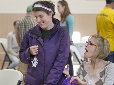 Kelly McRuvie and Tammy Stevens are all smiles after finishing her snowflake decoration. Special Olympic Athletes spent the afternoon cutting, drawing and glueing hand made tree decorations before placing them on the tree bound for the 2015 City Hospital Foundation's Festival of Trees at the WDM, Nov. 12, 2015. All decoration represented the sports the participant are involved in. Volunteer parents and high school students from Holy Cross and Bishop James Mahoney High Schools also spent the afternoon helping out.
