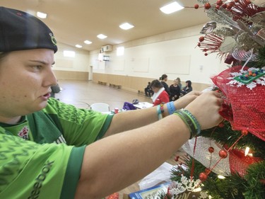 Morgan Schuler helped decorate the Special Olympic Athletes tree after first spending time  cutting, drawing and glueing before hanging their hand made tree decorations on the tree bound for the 2015 City Hospital Foundation's Festival of Trees at the WDM, Nov. 12, 2015. All decoration represented the sports the participant are involved in. Volunteer parents and high school students from Holy Cross and Bishop James Mahoney High Schools also spent the afternoon helping out.