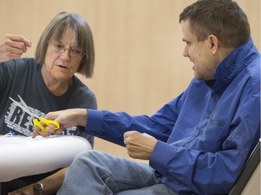 A volunteer helps Ian Cushon cut out shapes to make his next decoration at a afternoon where Special Olympic Athletes spent the afternoon cutting, drawing and glueing hand made tree decorations before placing them on the tree bound for the 2015 City Hospital Foundation's Festival of Trees at the WDM, Nov. 12, 2015. All decoration represented the sports the participant are involved in. Volunteer parents and high school students from Holy Cross and Bishop James Mahoney High Schools also spent the afternoon helping out.