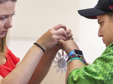 Volunteer Jai-Lyn Melnychuk  helps Morgan Schuler with his soccer ball shaped decoration attached at decorating bee where Special Olympic Athletes spent the afternoon cutting, drawing and glueing hand made tree decorations before placing them on the tree bound for the 2015 City Hospital Foundation's Festival of Trees at the WDM, Nov. 12, 2015. All decoration represented the sports the participant are involved in. Volunteer parents and high school students from Holy Cross and Bishop James Mahoney High Schools also spent the afternoon helping out.