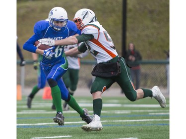 Moose Jaw Peacock Tornadoes' Teagen Anderson tackles Saskatoon Bishop Mahoney Saints' Michael Baker in 3A Football Provincial finals at SMS field in Saskatoon, November 14, 2015.