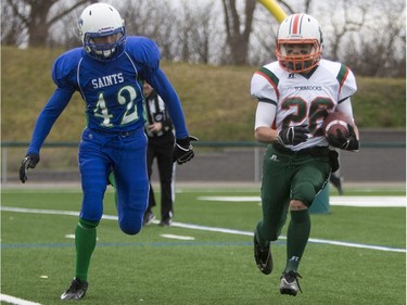 Moose Jaw Peacock Tornadoes' Mark Warburton runs the ball against Saskatoon Bishop Mahoney Saints' Trace Dielscheider in 3A Football Provincial finals at SMS field in Saskatoon, November 14, 2015.