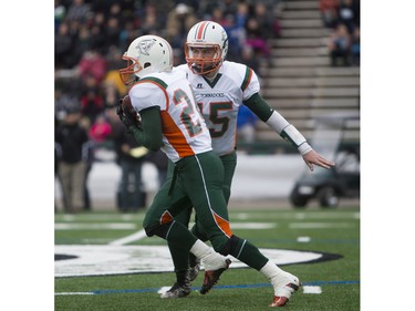 Moose Jaw Peacock Tornadoes quarterback Kurtis Busch (R) hands the ball off to teammate Kyle Arndt against the Saskatoon Bishop Mahoney Saints in 3A Football Provincial finals at SMS field in Saskatoon, November 14, 2015.