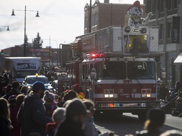 Saskatoon Firefighters mascot Sparky the Fire Dog waves as the Santa Claus parade makes its way down Second Avenue North in Saskatoon, November 15, 2015.