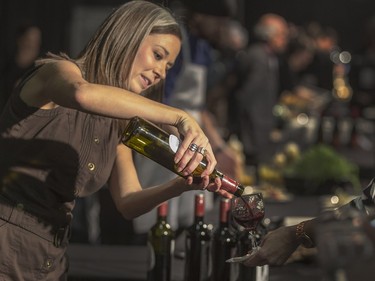 A sommelier from Red Rooster Wineries pours for guests at the Gold Medal Plates Dinner at Prairieland Park, Friday, Nov. 20, 2015.