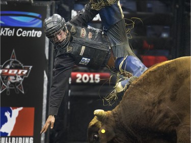 A bull rider flies through the air after a ride at PBR Canadian Finals Bull Riding  in Saskatoon at SaskTel Centre, Friday, Nov. 20, 2015.