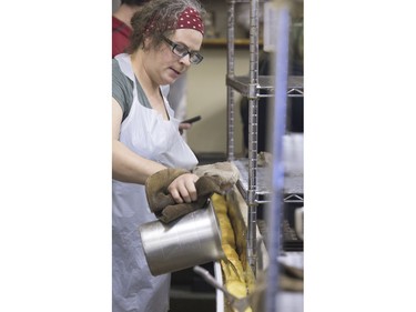 Carmen Dyck continually pours hot cooking oil over this donut dough to cook the 19-foot long john in this eavestrough at Nestor's Bakery where students of the Community Learner's High School are attempting to make the world's longest long john donut, November 24, 2015. It measured in at just over 19' 1 1/2" long.