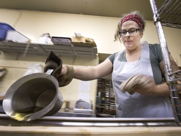 Carmen Dyck continually poured hot cooking oil over this donut dough to cook a 19-foot long john in an eavestrough at Nestor's Bakery where students of the Community Learner's High School are attempting to make the world's longest long john donut, November 24, 2015. It measured in at just over 19' 1 1/2" long.