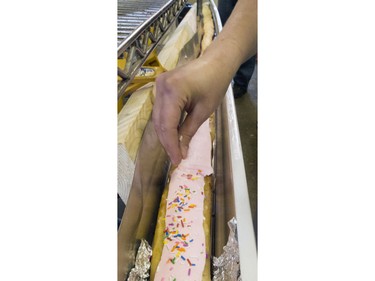 Icing and coloured sprinkles cover the top of the 19-foot long john that was cooked in this eavestrough at Nestor's Bakery where students of the Community Learner's High School are attempting to make the world's longest long john donut, November 24, 2015. It measured in at just over 19' 1 1/2" long.