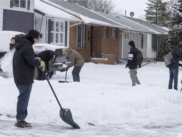 Josh Weibe's Wellness 10 class with the help of intern Andrew Abbs were just finishing up class shovelling snow off of sidewalks and driveways in the area of the 300 block of Avenue U and V North "giving a little bit back to the community," November 25, 2015.