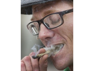 Shane Moore smokes a joint at City Hall before speaking to the media at a pot protest in conjunction with the charges last week against Mark Hauk, November 4, 2015. Moore was hurt working on the oil rigs and uses pot for the pain he endures.
