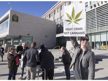 Supporters gather with signs during a pro-marijuana rally in front of Saskatoon Police headquarters, October 31, 2015.