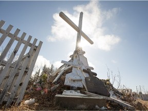 A collection of grave markers sits in the centre of a cemetery in La Loche