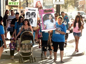 Carol Wolfe, in blue at right, mother of missing Karina Wolfe, leads supporters in a walk and vigil on 20th Street on July 2, 2013.