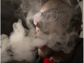 SASKATOON,SK--MARCH 23/2014--  StarPhoenix reporter Jeremy Warren, who is working on quitting smoking,  vapes around town Wednesday, April 23, 2014, including here at work, for a story about reaction to vaping.  (GREG PENDER/STAR PHOENIX)