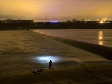 People fish at the weir in the South Saskatchewan River in a time exposure, November 9, 2015.