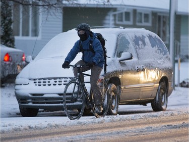 Saskatoon was coated in its first snowfall of the year following an overnight rain which made roads slippery for motorists and pedestrians, November 18, 2015. Here a cyclist makes his way down Cumberland Avenue.