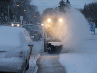 Saskatoon was coated in its first snowfall of the year following an overnight rain which made roads slippery for motorists and pedestrians, November 18, 2015. A snow blower works on Grosvenor Avenue before sunrise.