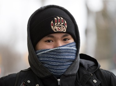 Saskatoon was coated in its first snowfall of the year following an overnight rain which made roads slippery for motorists and pedestrians, November 18, 2015. Daylen Moccasin covers up from the cold downtown.