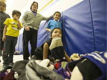 Students from St. Michael School, including Brody Brittain with a toque in his teeth, dove right in during the annual Coats for Kids news conference at the school, November 19, 2015. Hundreds of coats and warm winter accessories were collected through the Rock 102 Coats for Kids Campaign this year.