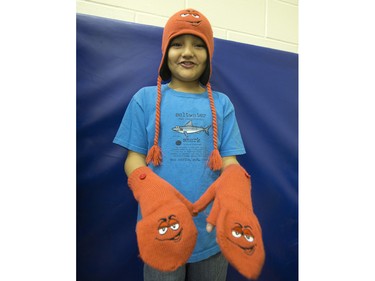 Students from St. Michael School dove right in during the annual Coats for Kids news conference at the school, November 19, 2015. Grade Four student Leland Johnson shows off a toque and gloves he found in one pile.