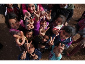 Syrian refugees pose for a photo at an unofficial refugee camp on the outskirts of Amman, Jordan, in 2014.