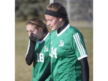 University of Saskatchewan Huskies midfielder defenders Erica Parenteau (L) and Jennifer Miller leave the field after the University of Calgary Dinos defeat the Huskies in CIS women's soccer playoff action, November 8, 2015.