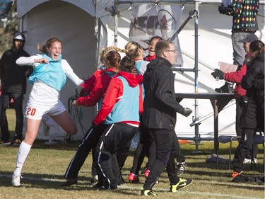 University of Calgary Dinos bench celebrates a goal against the University of Saskatchewan Huskies during the second half of CIS women's soccer playoff action, November 8, 2015.