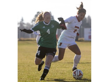 University of Saskatchewan Huskies striker Jenelle Zapski battles for the ball with University of Calgary Dinos midfielder Kayla Kreutzer during the first half of CIS women's soccer playoff action, November 8, 2015.